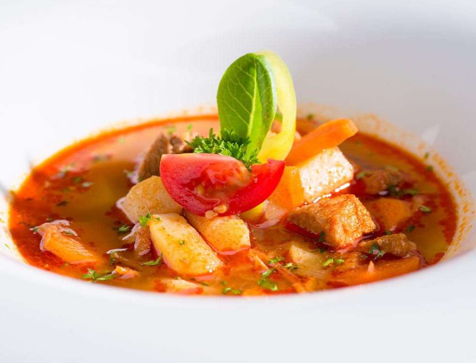 Vegetable and meat soup in a white bowl